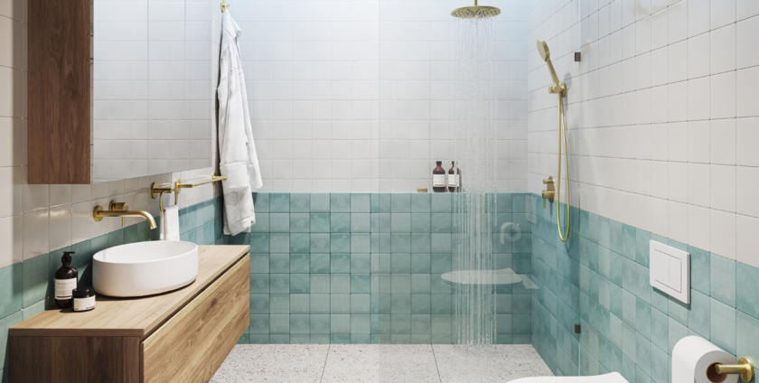 Modern bathroom with turquoise wall tiles, terrazzo flooring, floating wooden vanity, and gold fixtures.