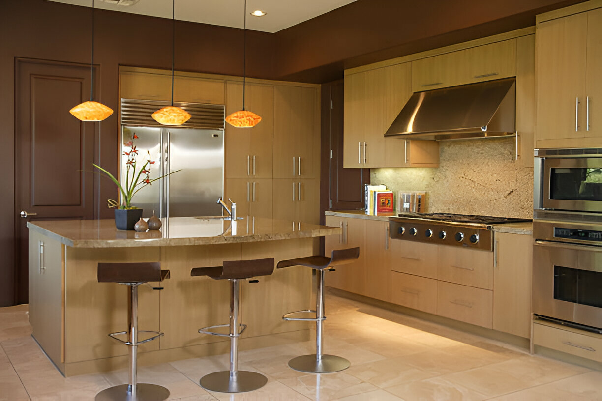 Modern kitchen with wood cabinetry, granite countertops, stainless steel appliances, pendant lighting, and barstool seating at the island