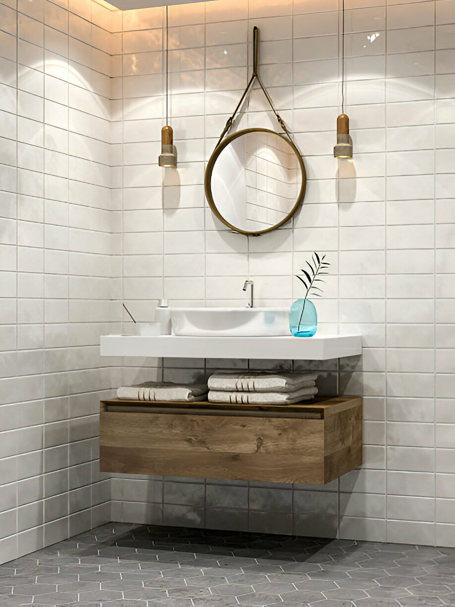A modern bathroom with a floating wooden vanity, white vessel sink, round hanging mirror, and warm pendant lighting.