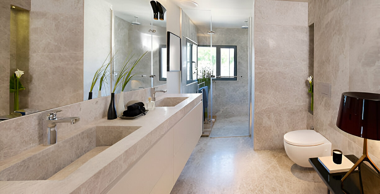 A modern bathroom featuring a sleek double vanity, marble walls, a walk-in shower, and a floating toilet.