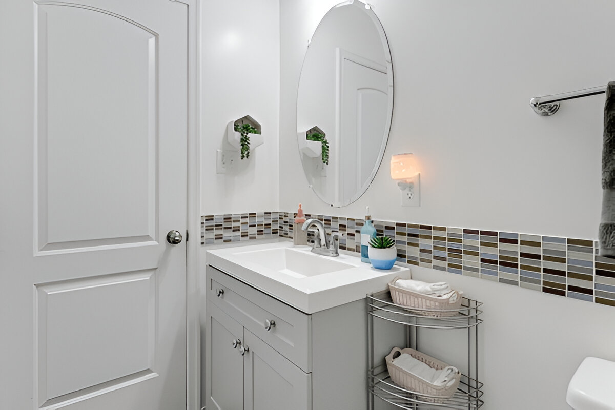 Modern bathroom vanity with oval mirror and colorful mosaic tile backsplash