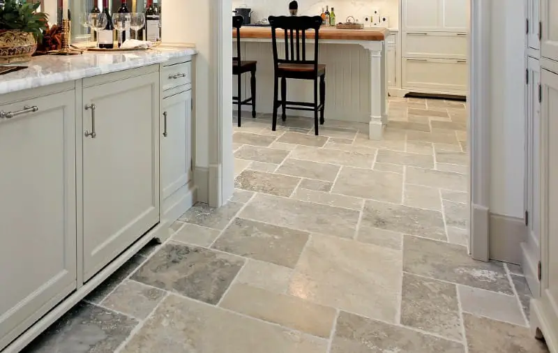 Natural stone tile flooring in a traditional kitchen with cream cabinetry