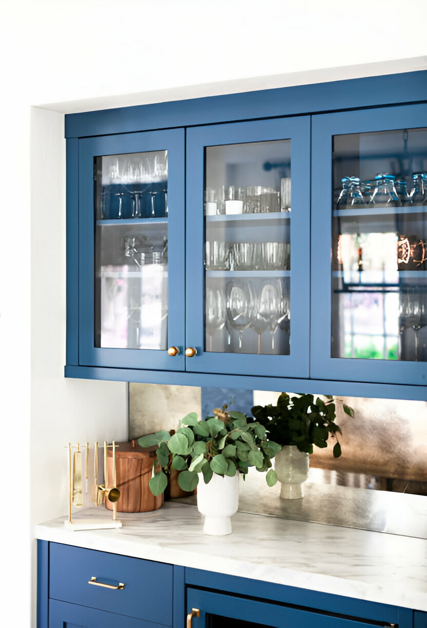 Blue kitchen cabinet with glass doors showcasing elegant glassware