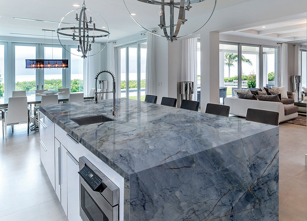 Contemporary kitchen with a striking blue marble waterfall island, modern fixtures, and oceanfront view