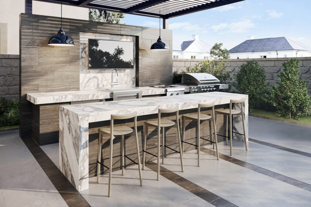 Modern outdoor kitchen featuring marble waterfall countertops, stainless steel grill, bar seating, and pergola