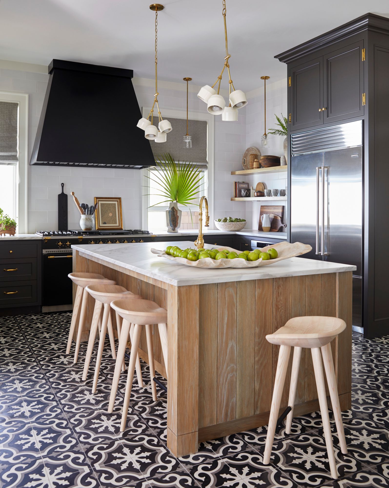 Stylish kitchen with dark cabinetry, patterned floor tiles, and wooden island