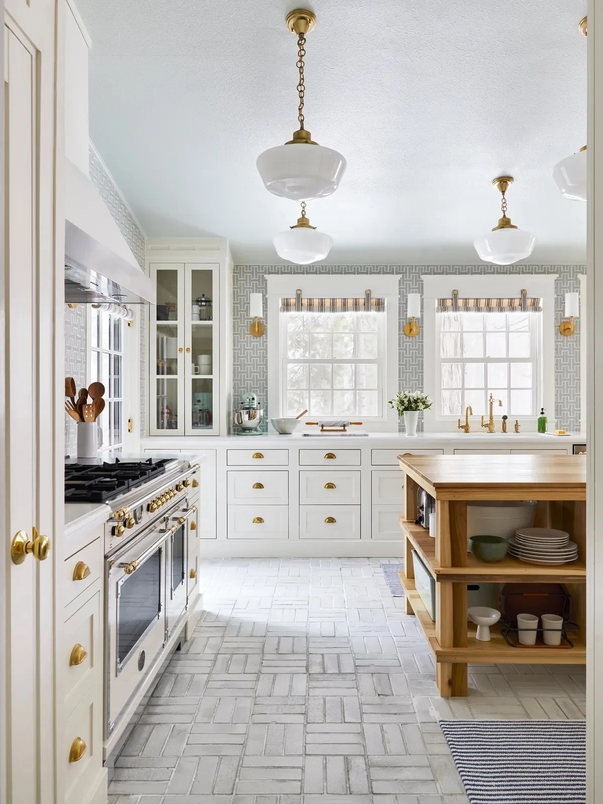 Bright kitchen with white cabinets, gold hardware, and interlocking tile backsplash