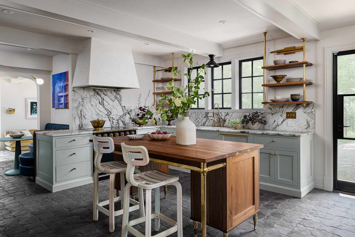 Eclectic kitchen with marble backsplash, wooden island, and sage green cabinets