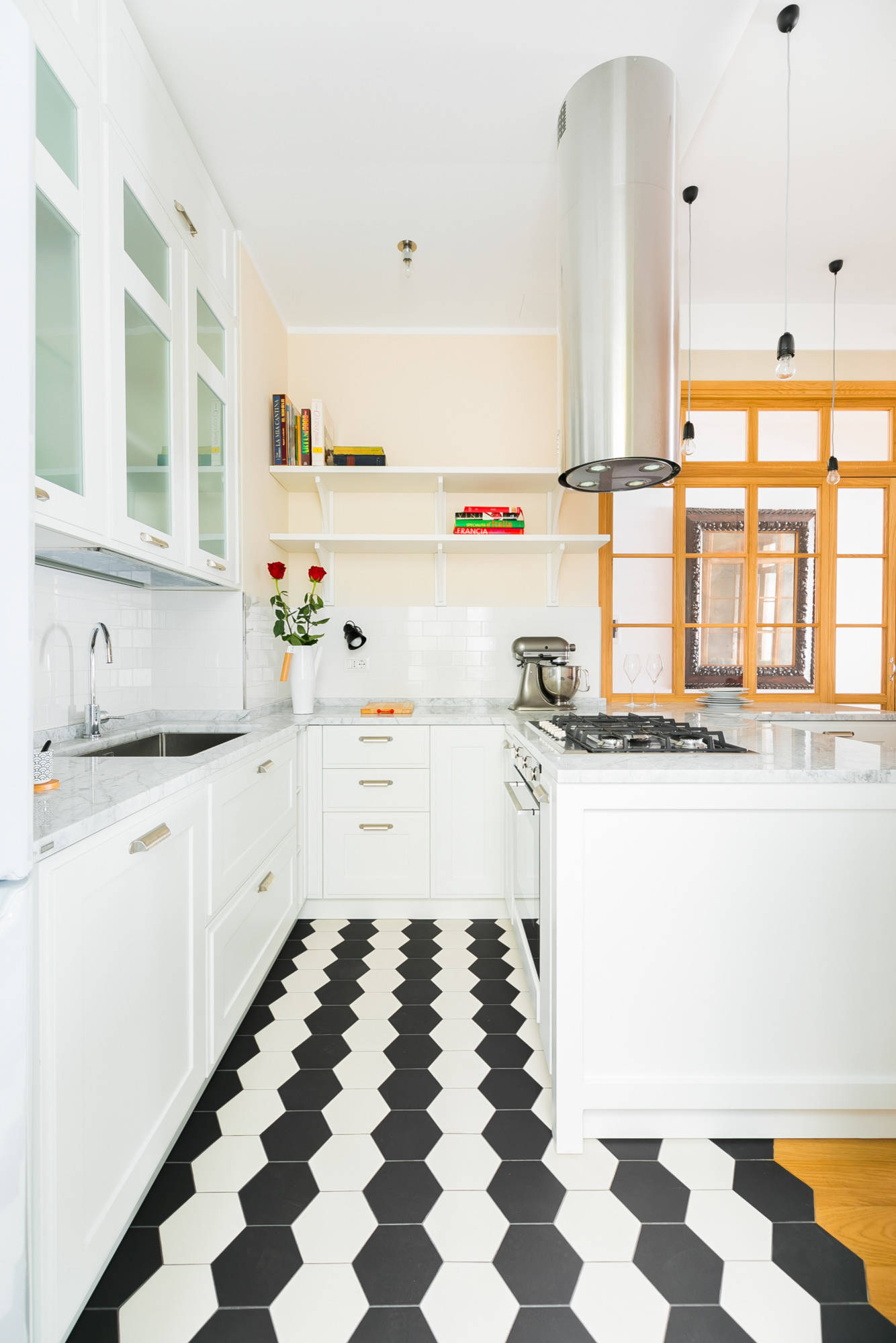 Bright white kitchen with hexagon tile flooring and modern pendant lights