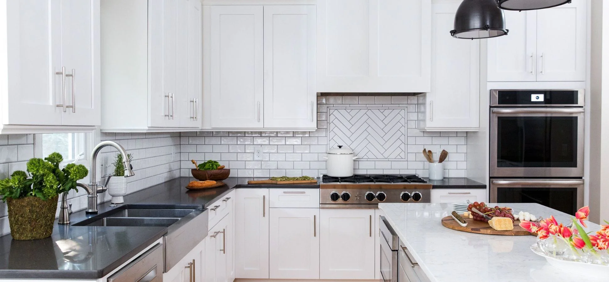 White modern kitchen with subway tile backsplash and dark countertops