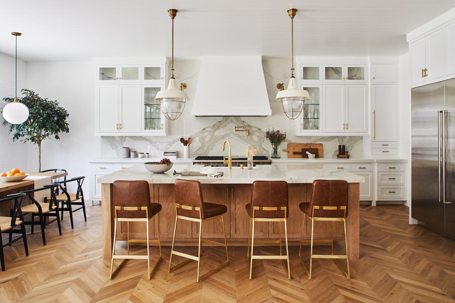 Elegant kitchen with herringbone wood flooring and marble island