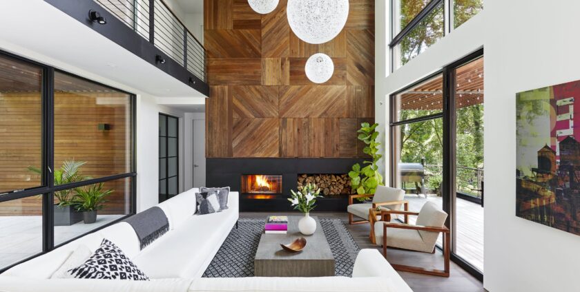 Modern living room with tall windows, wood accent fireplace wall, and white sectional sofa