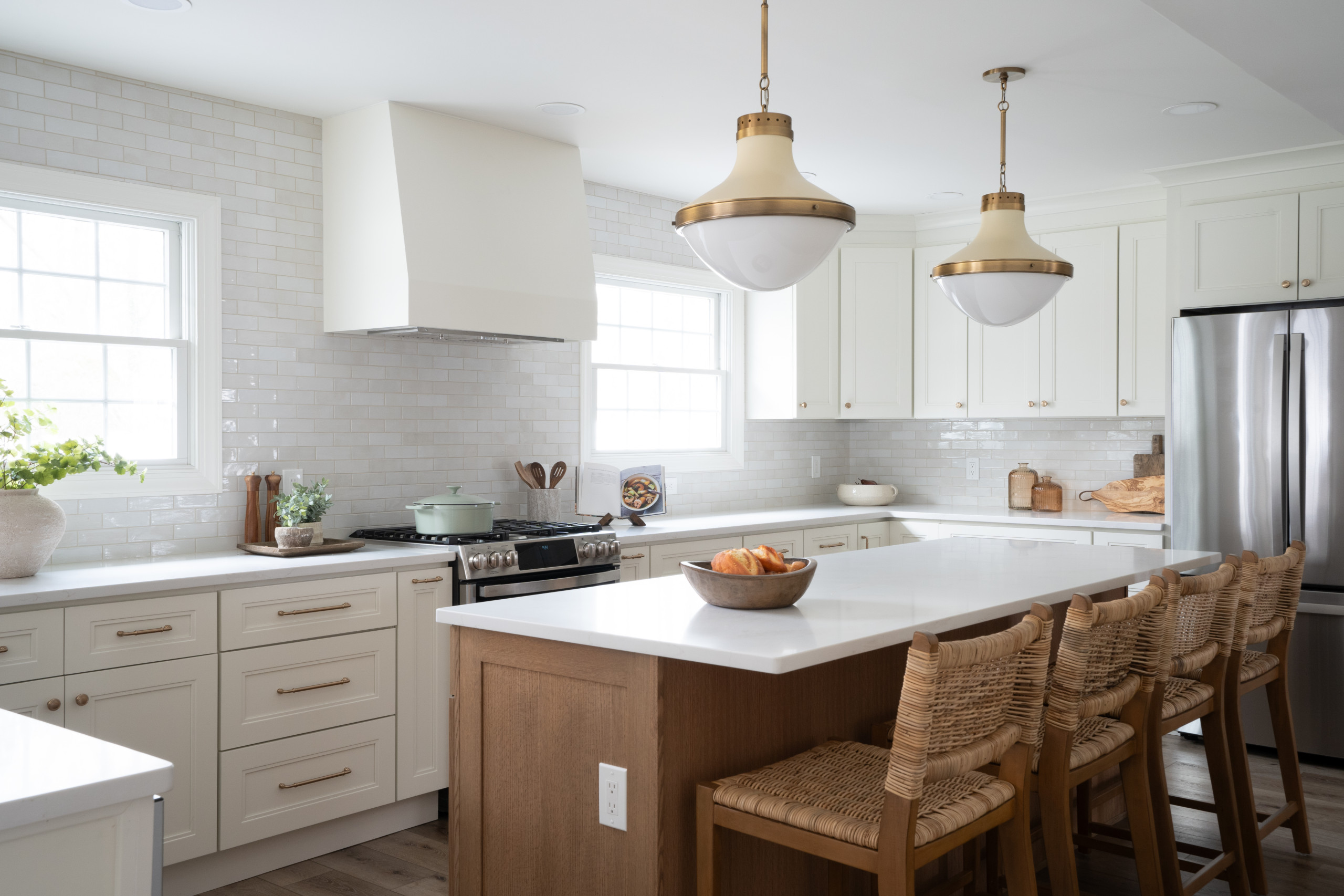 Bright kitchen with white cabinets, subway tile backsplash, and wooden island