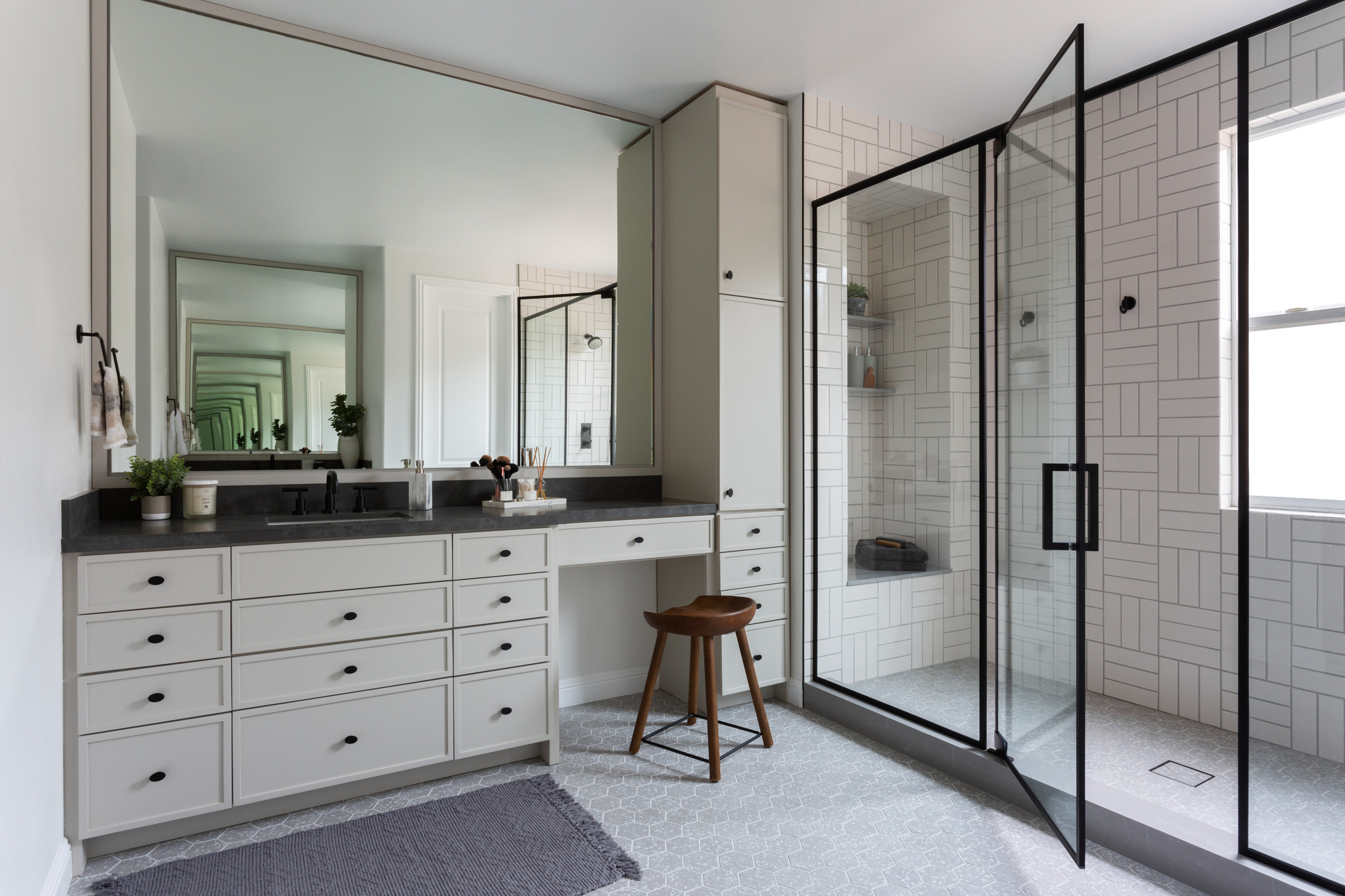 Modern bathroom with built-in vanity, black countertop, and glass shower enclosure
