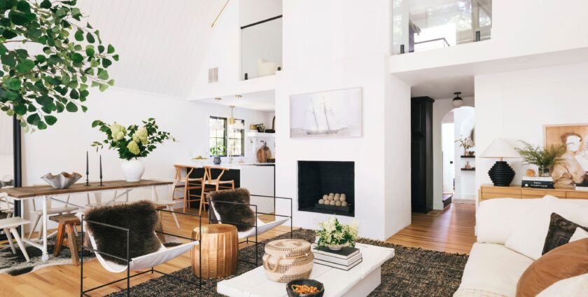 Bright modern living room with white walls, black fireplace, minimalist furniture, and natural wood accents.