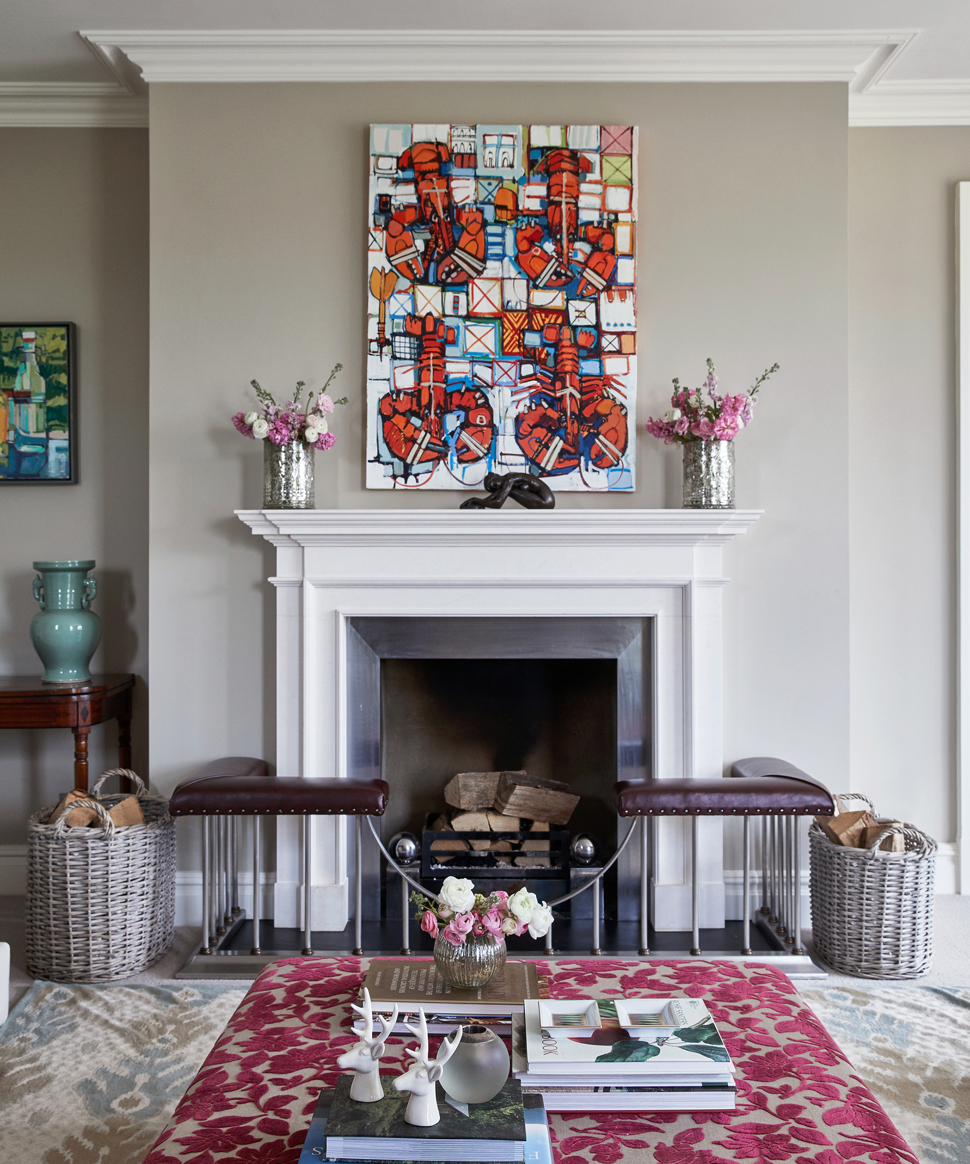 Modern living room with white fireplace mantel, colorful abstract artwork, and floral decor.