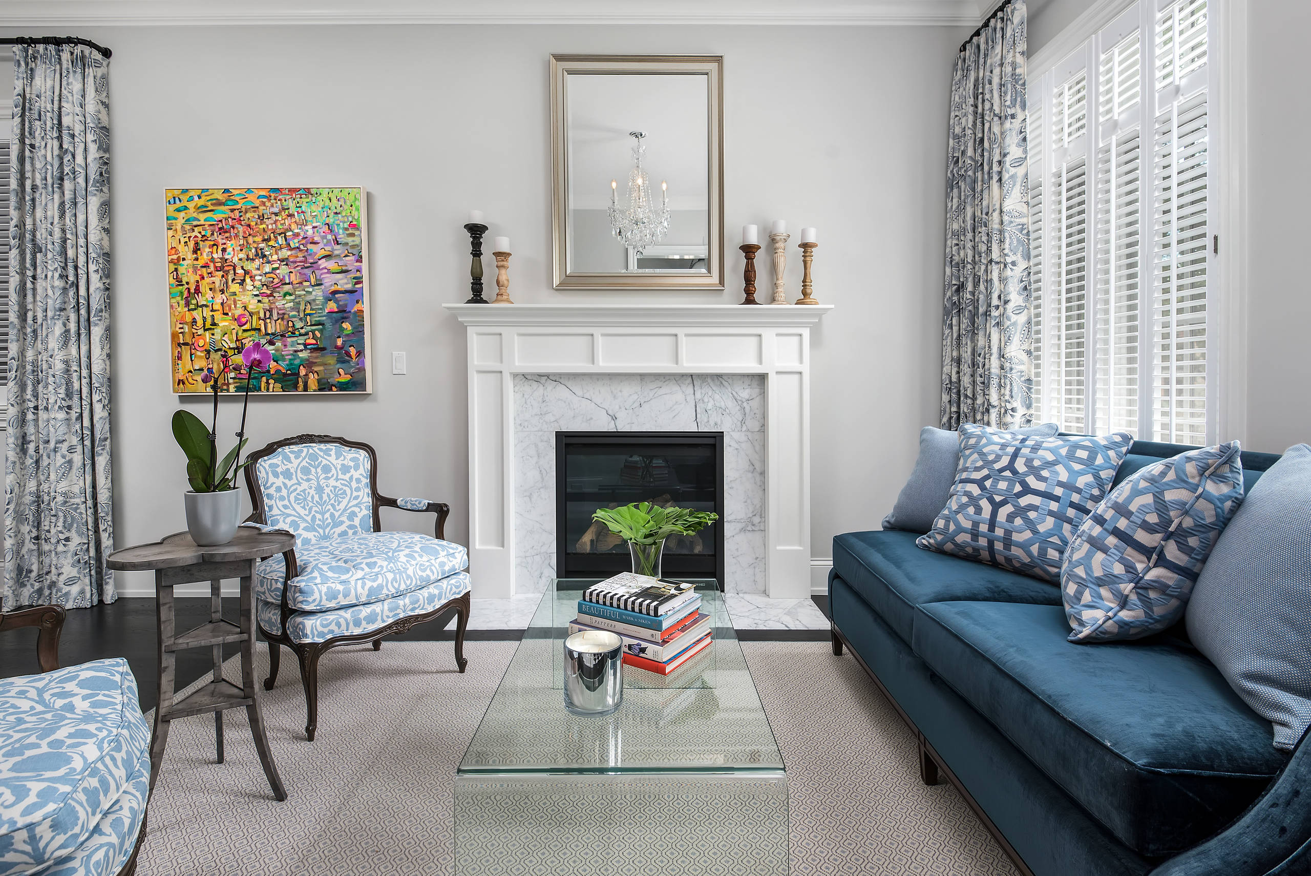 Elegant living room with blue furniture, fireplace, and colorful artwork