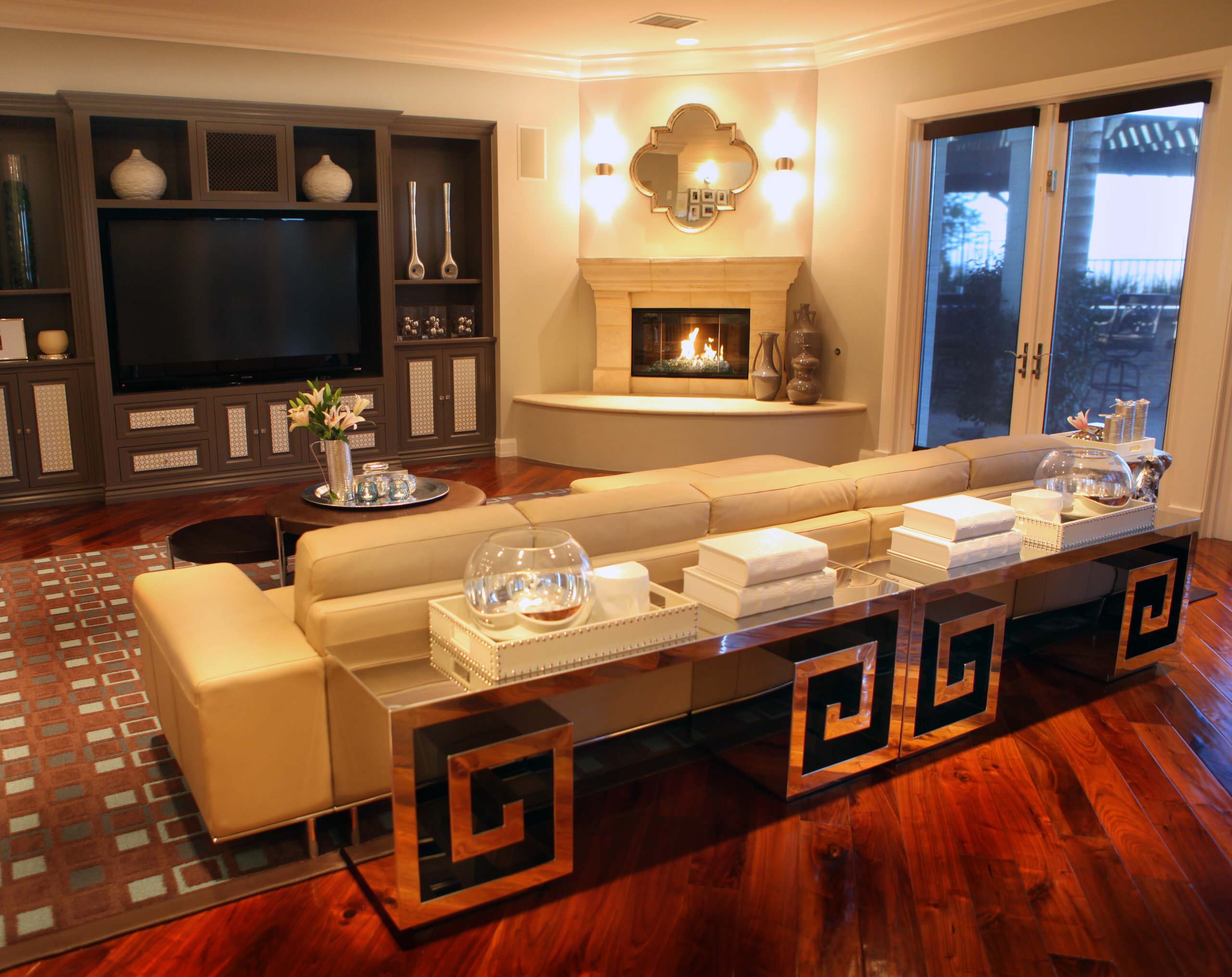 Luxury family room with corner fireplace, entertainment unit, and modern décor