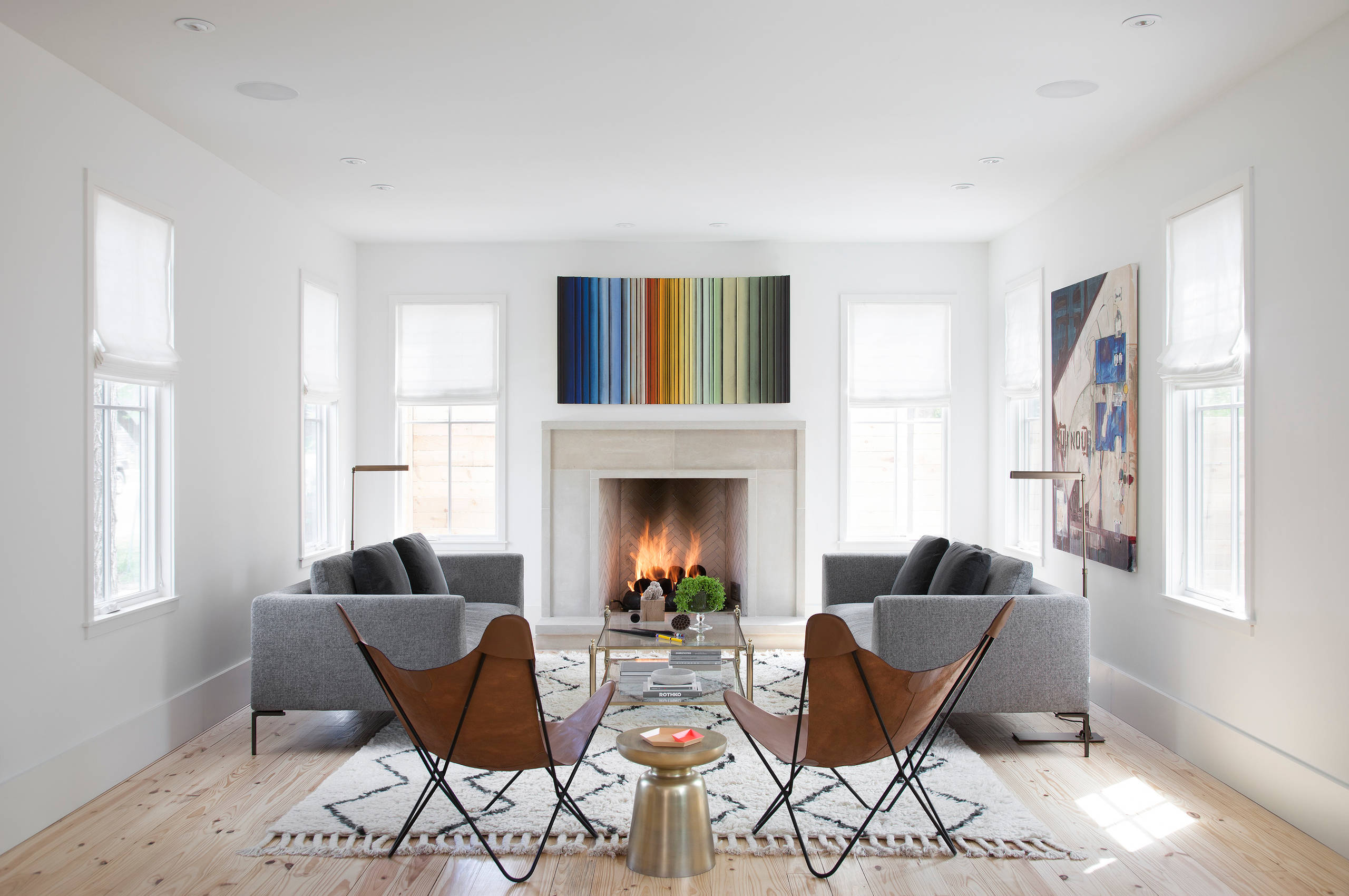 Modern living room with fireplace, gray sofas, and contemporary artwork