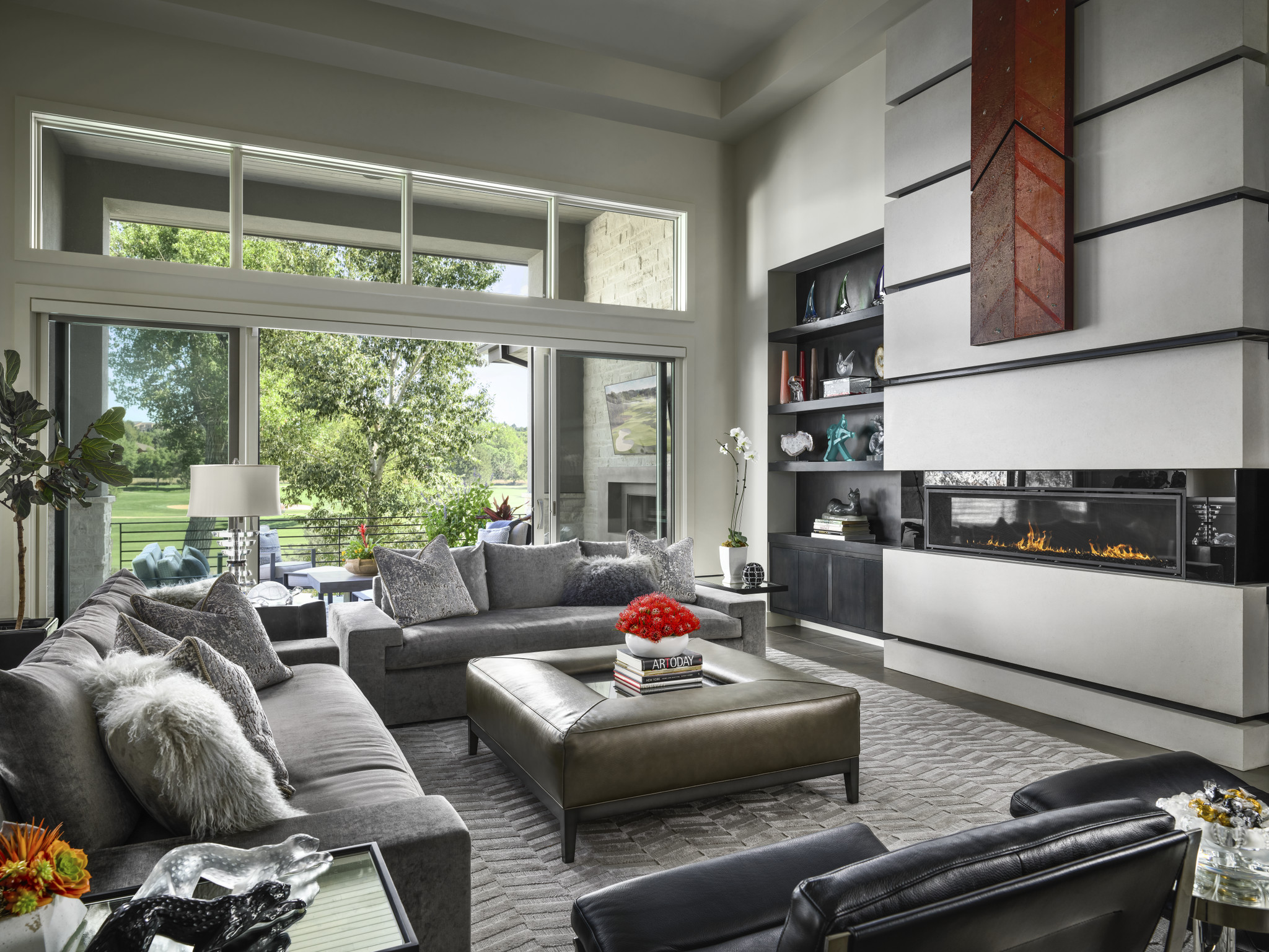 Luxury living room with modern fireplace, gray sectional sofas, and large windows