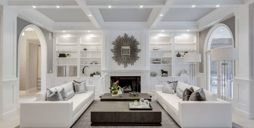 Luxury living room with white sofas, modern fireplace, and built-in shelving.