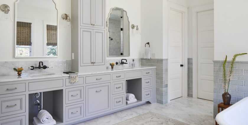 Elegant bathroom with dual vanities, gray cabinetry, and marble finishes