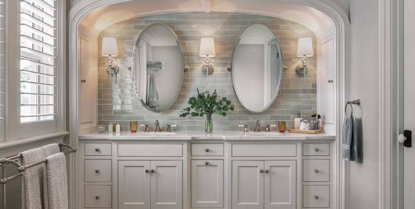 Elegant bathroom vanity with double sinks, oval mirrors, and soft lighting
